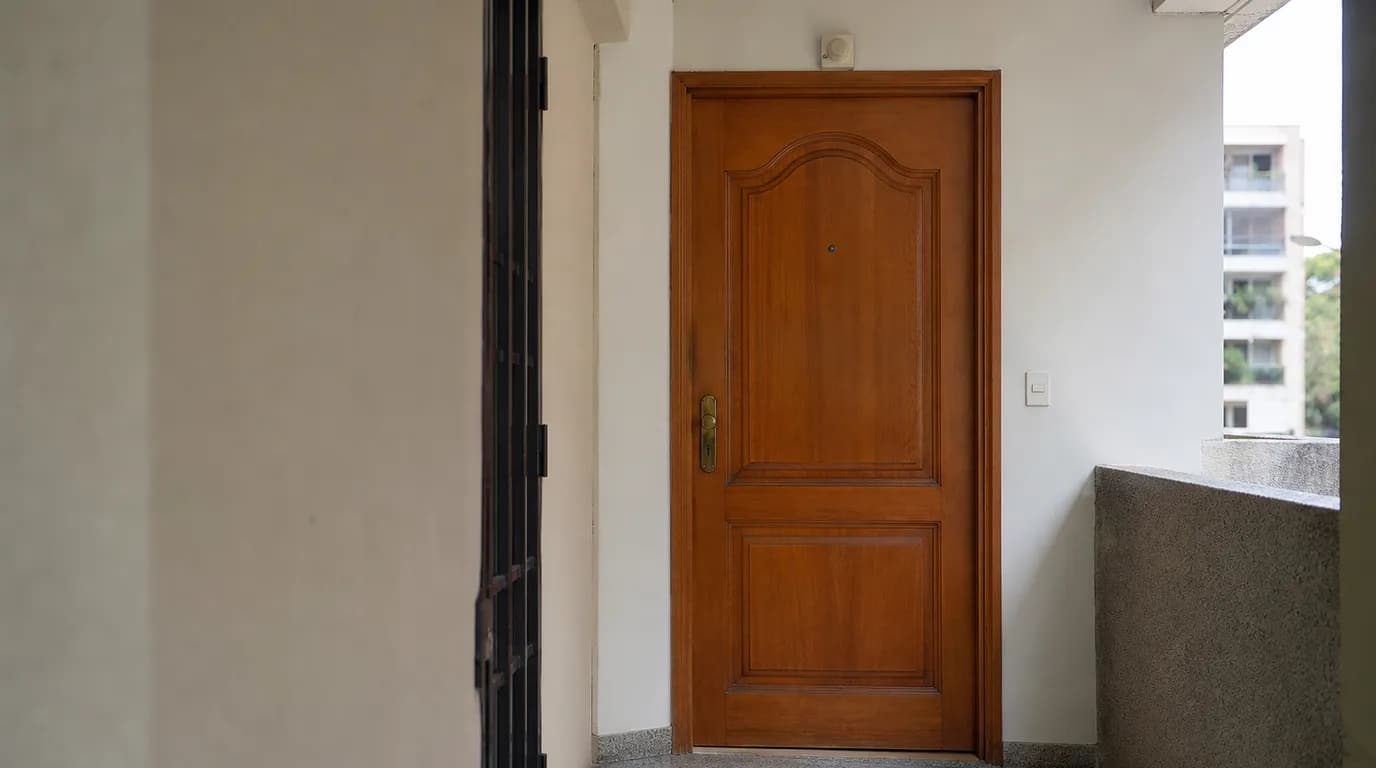 Edificio residencial venezolano con la puerta de un apartamento cerrada, vista de un pasillo común
