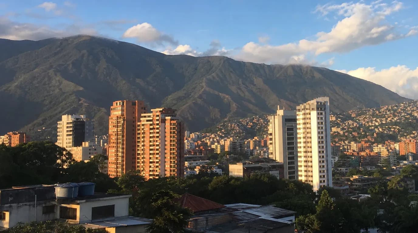 View of Caracas with the Ávila in the background and modern apartment towers under warm sunset light