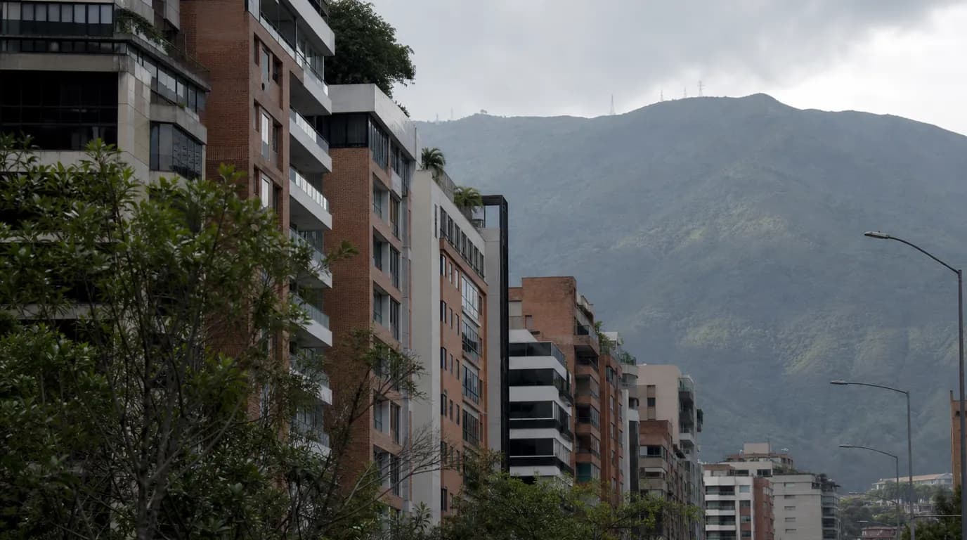 Edificios residenciales modernos en una avenida de Caracas con El Ávila al fondo