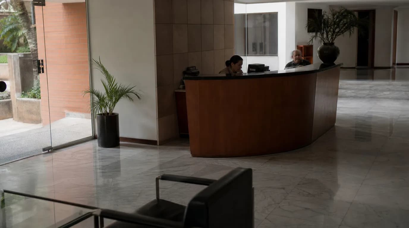 Recepción y áreas comunes de un edificio residencial venezolano con la mesa de administración del condominio
